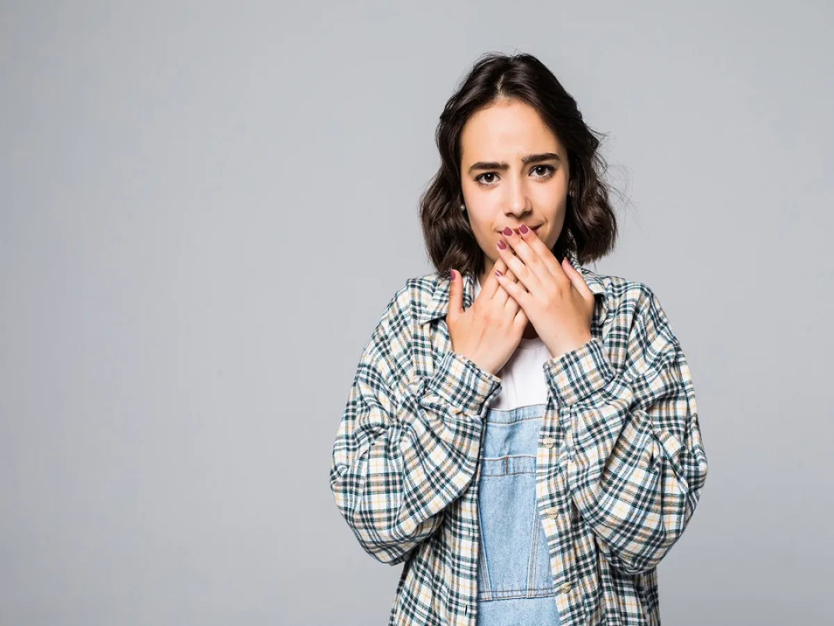 صورة لامرأة تضع يديها علي فمها