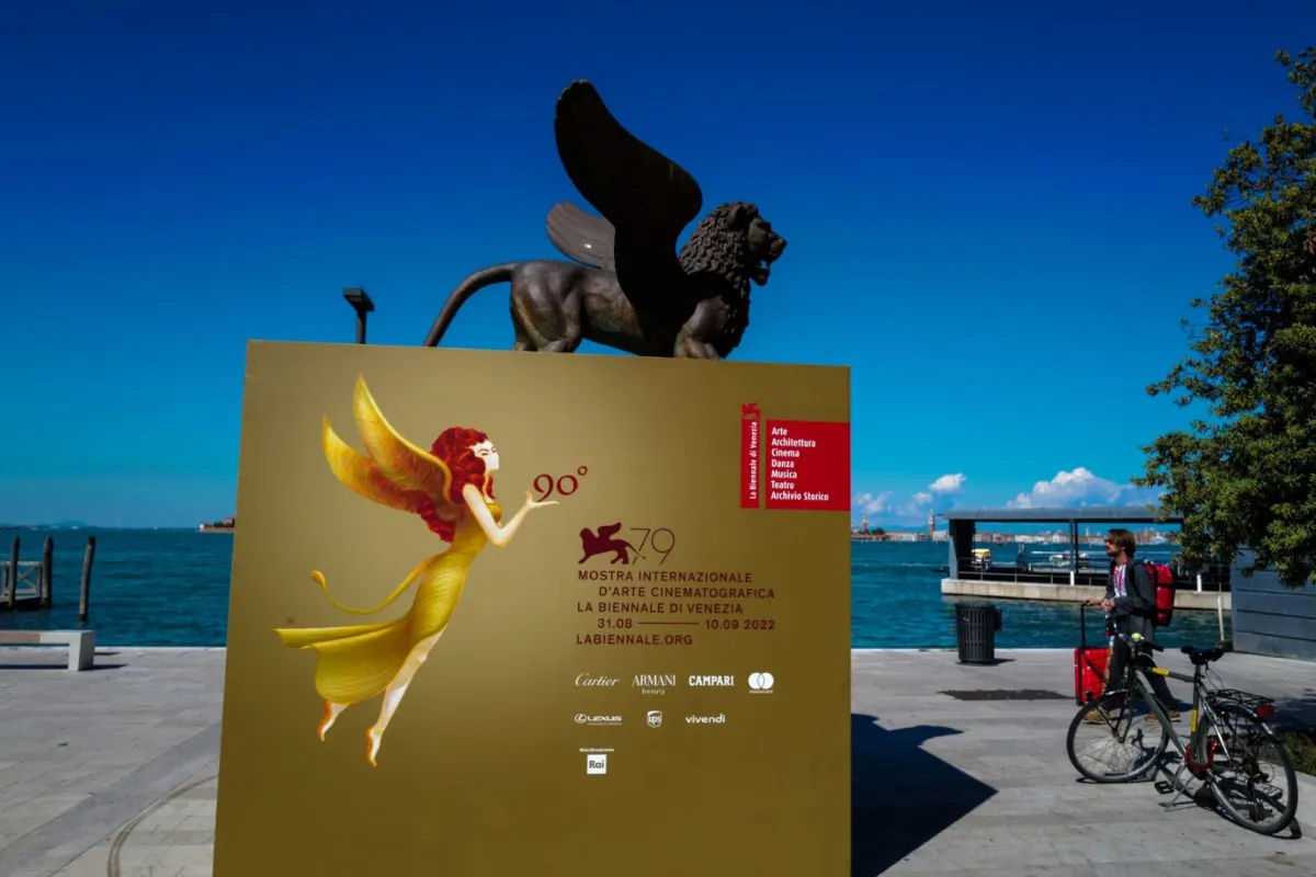 تصوير تمثال لأسد مجنح، يرمز إلى مدينة فينيسيا، والملصق الرسمي لمهرجان فينيسيا السينمائي الدولي التاسع والسبعين في 10 سبتمبر 2022 (A sculpture of a winged lion, which symbolizes the city of Venice, and the official poster of the 79th Venice International Film Festival is pictured on September 10, 2022). مصدر الصورة: Andreas SOLARO / AFP