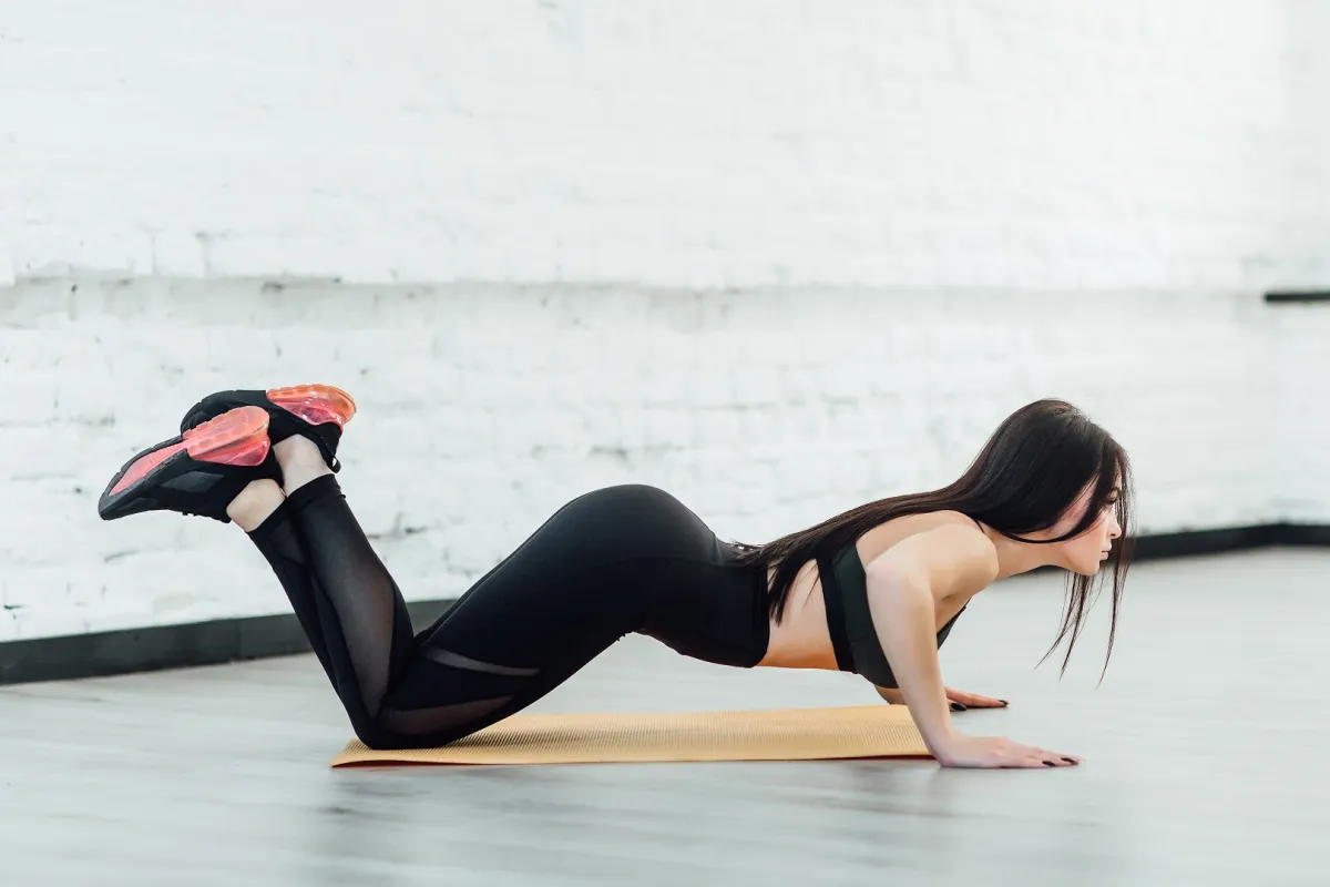 ضعي وزنكِ على ركبتيكِ بينما تتجه يداكِ لأسفل أثناء ممارسة تمارين الضغط (المصدر: Freepik)