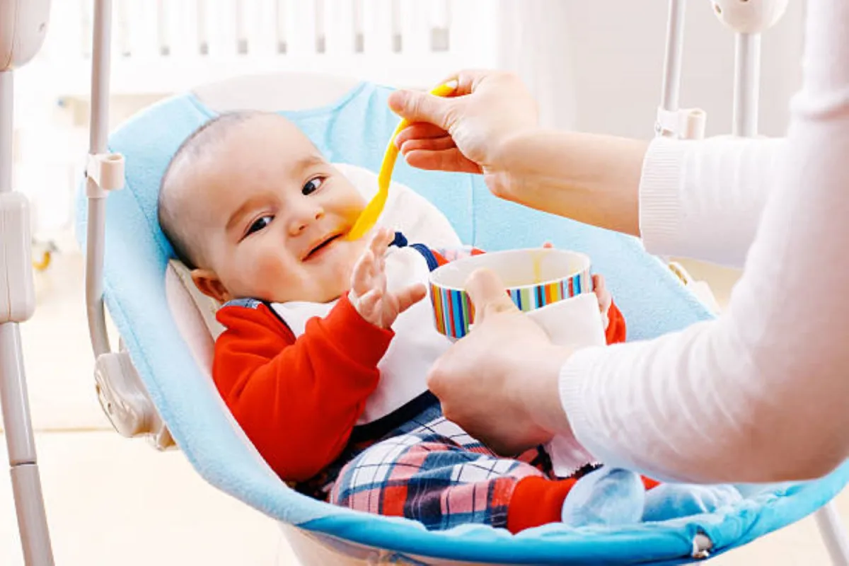 صورة لأم تقدم الطعام الصلب لرضيعها