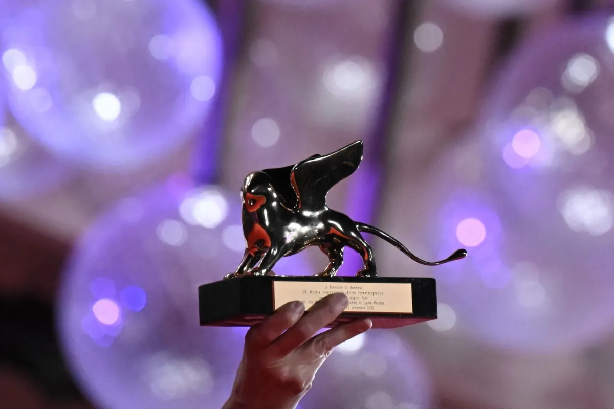 جائزة الأسد الذهبي تحملها المخرجة الأمريكية لورا بويتراس (US director Laura Poitras holds the Golden Lion for Best Film). مصدر الصورة:  Tiziana FABI / AFP