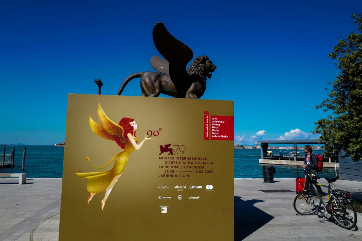 تمثال لأسد مجنح يرمز إلى مدينة البندقية، والملصق الرسمي لمهرجان البندقية السينمائي الدولي الـ 79 (A sculpture of a winged lion, which symbolizes the city of Venice, and the official poster of the 79th Venice International Film Festival). مصدر الصورة: Andreas SOLARO / AFP
