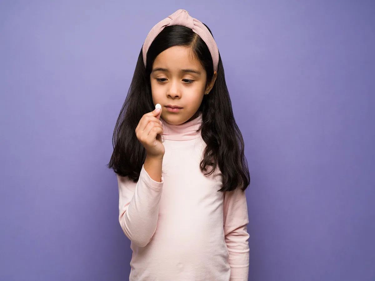 صورة لطفلة تحمل دواء