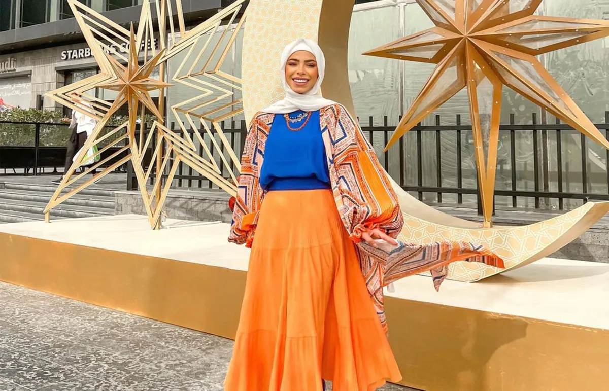 منة السُني بتنورة طويلة باللون البرتقالي