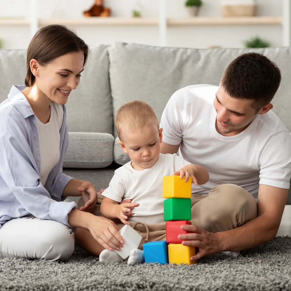 صورة لأم وأب يقدمان اللعب للرضيع