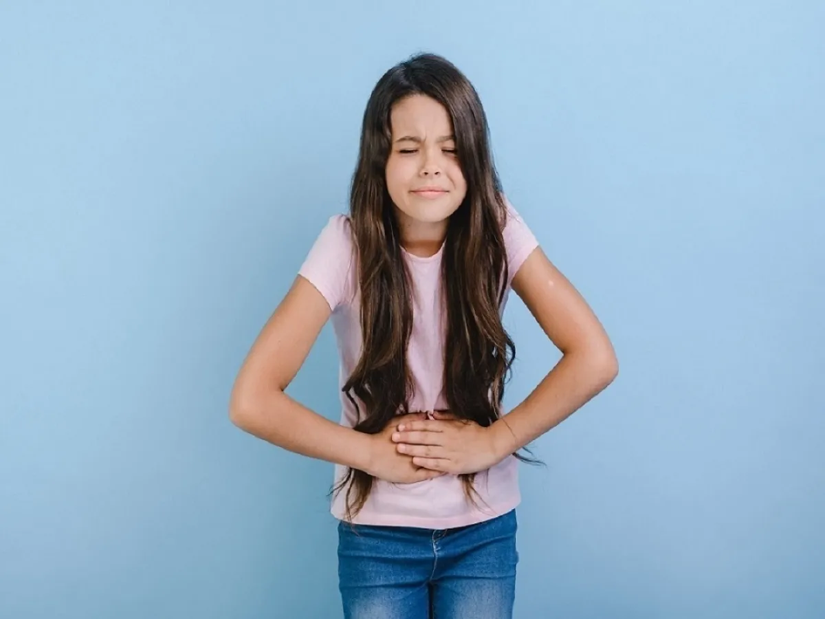صورة لفتاة تضع يديها على معدتها