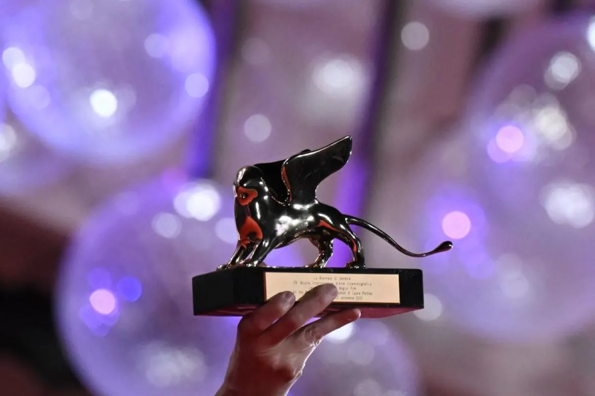 جائزة الأسد الذهبي تحملها المخرجة الأمريكية لورا بويتراس (US director Laura Poitras holds the Golden Lion for Best Film). مصدر الصورة: Tiziana FABI / AFP