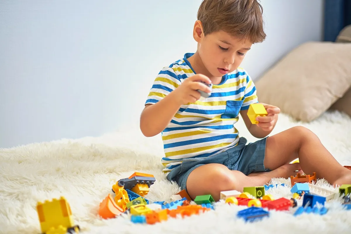 صورة لطفل يلعب ويمسك اللعب بإتقان