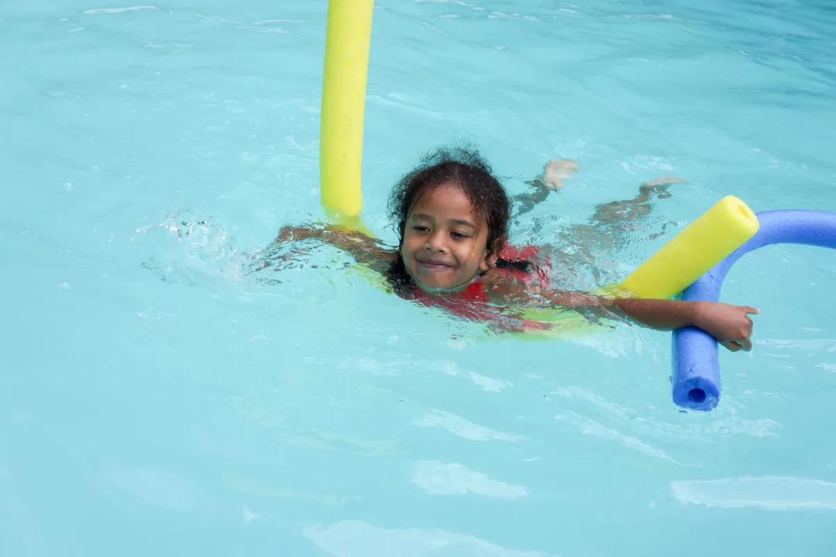 صورة طفلة تسبح مع نودلز البركة