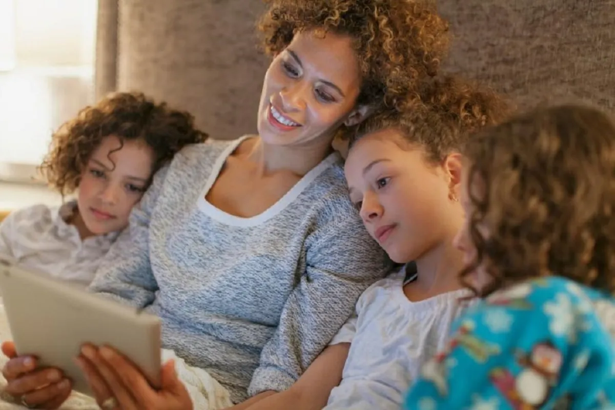 صورة لأم تقرأ قصة لبناتها