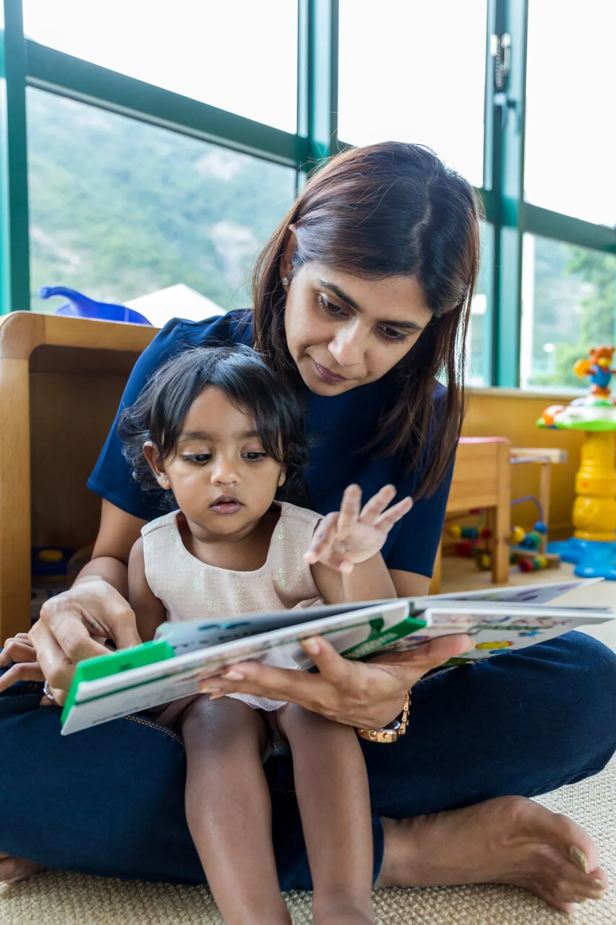 صورة أم تقرأ لطفلتها