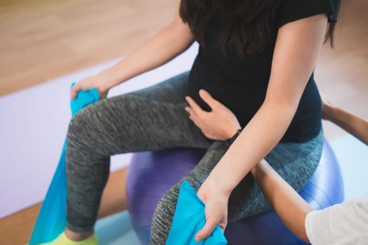 صورة لحامل تمارس تمارين التمدد على الكرة