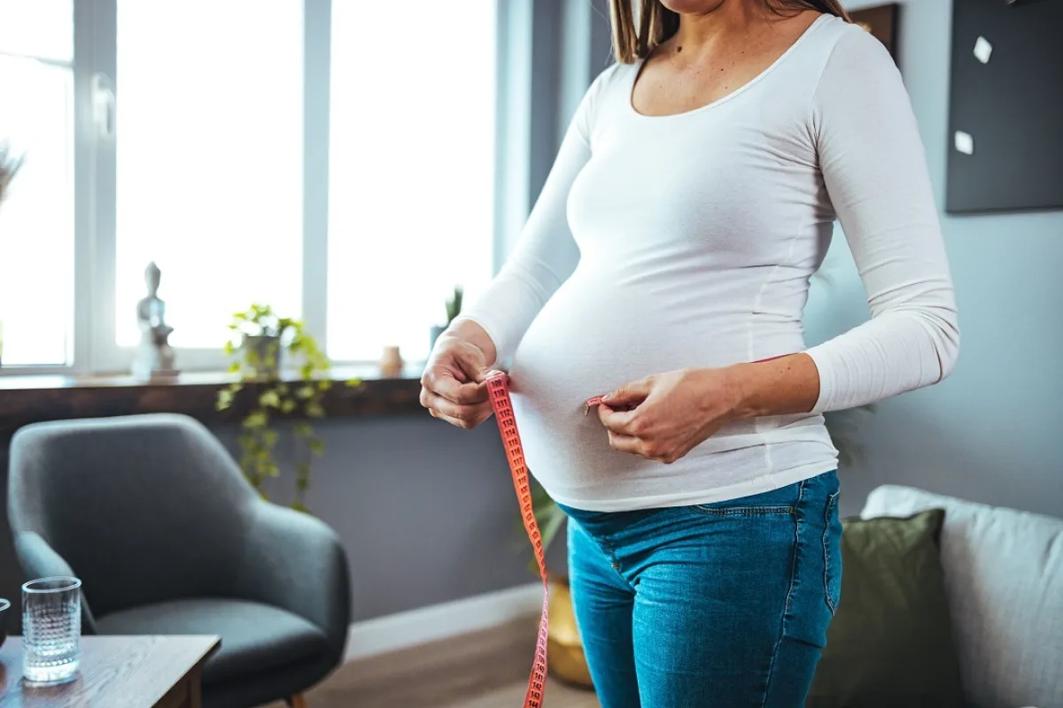 صورة لامرأة حامل تقيس محيط بطنها