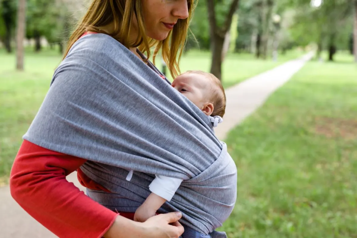 صورة لأم تحمل طفلها بالشيالة