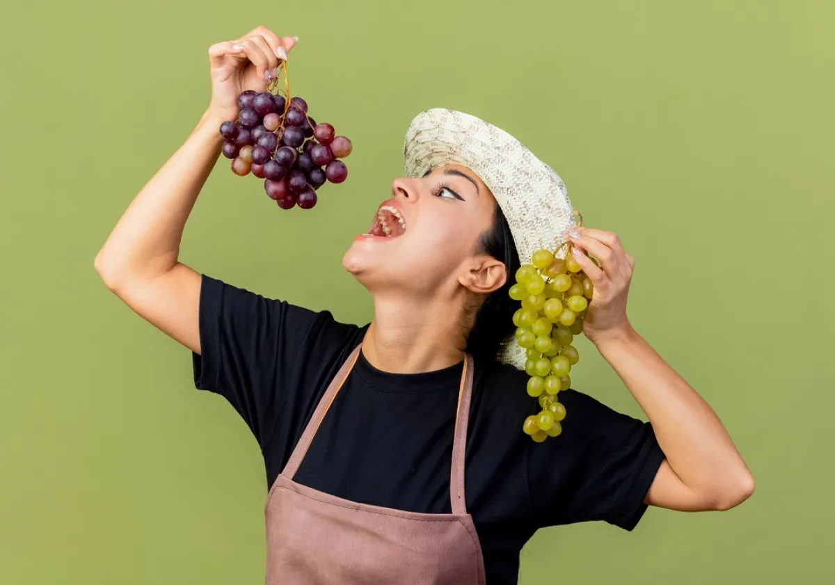 صورة لحامل تحمل عناقيد العنب