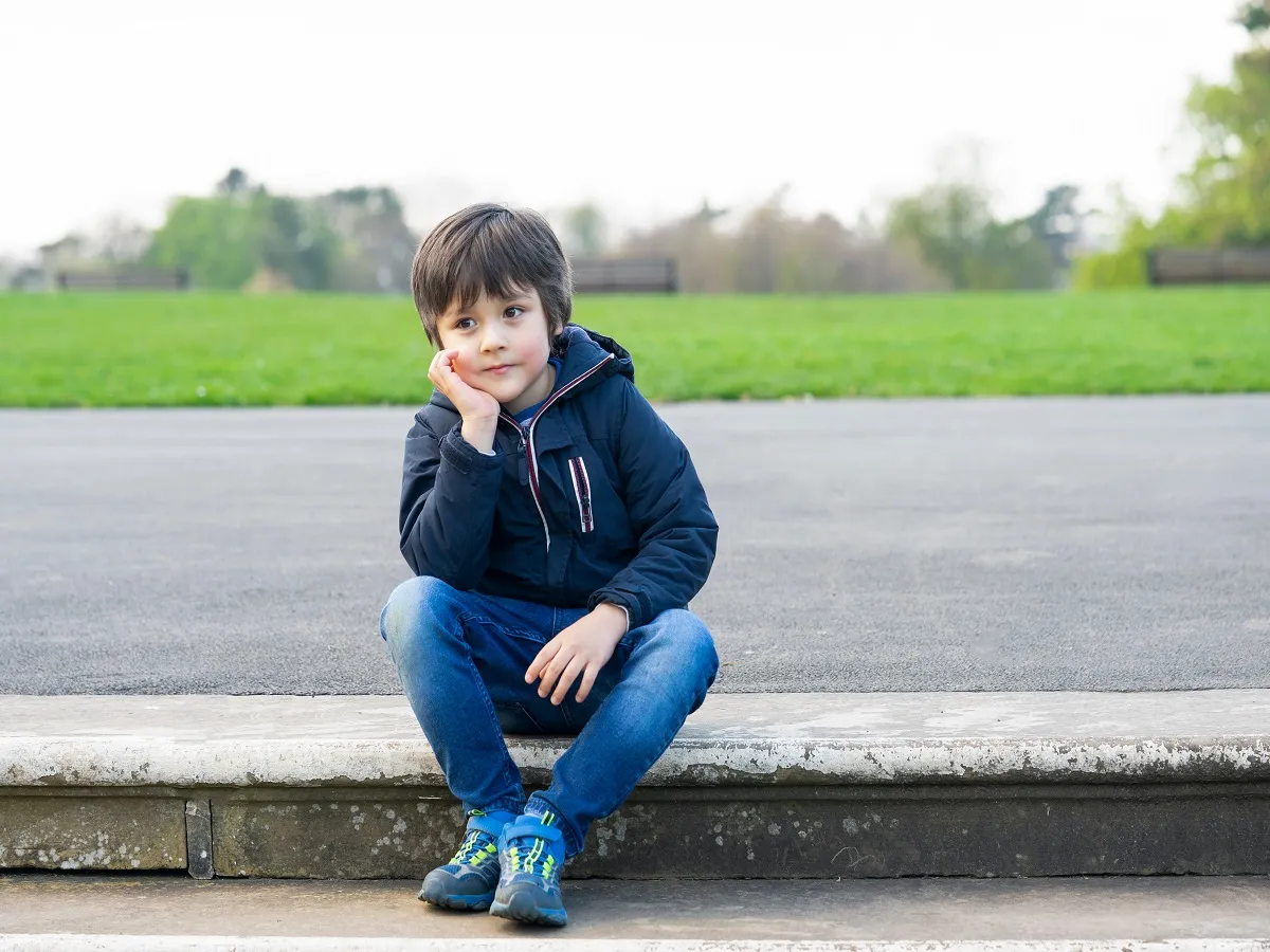 صورة لطفل يجلس وحيد