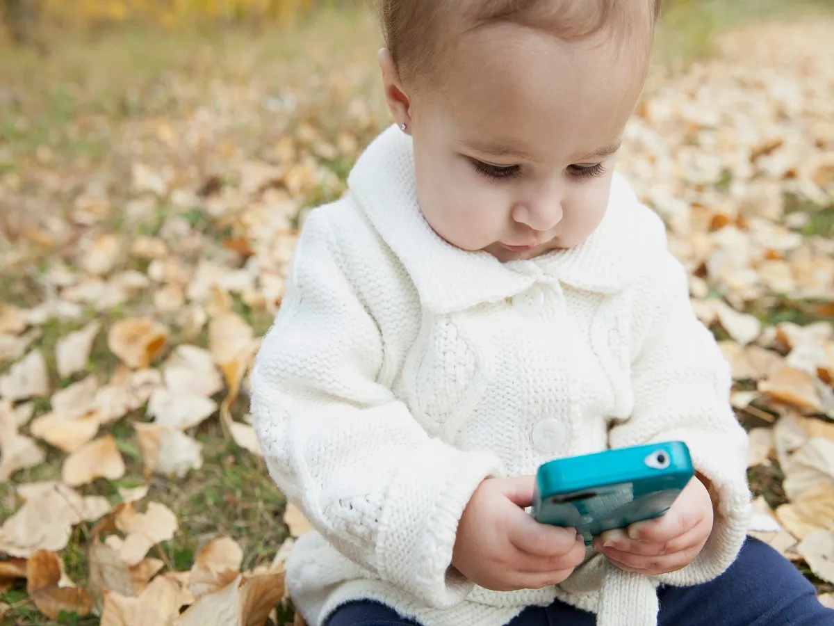 صورة لطفل يحمل هاتفاً محمولاً