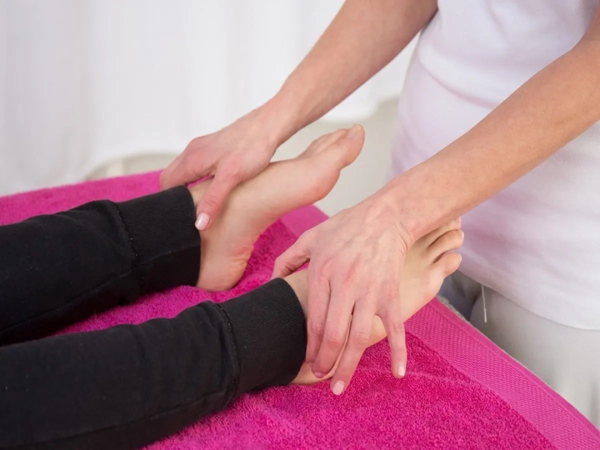 صورة لإخصائية تقوم بتدليك قدم امرأة