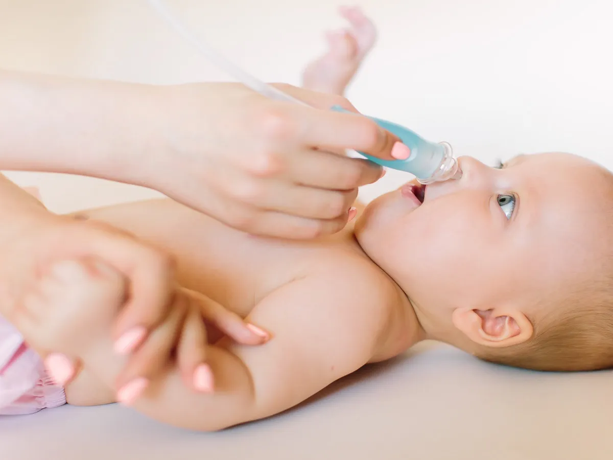 صورة لأم تنظف أنف طفلها الرضيع من المخاط