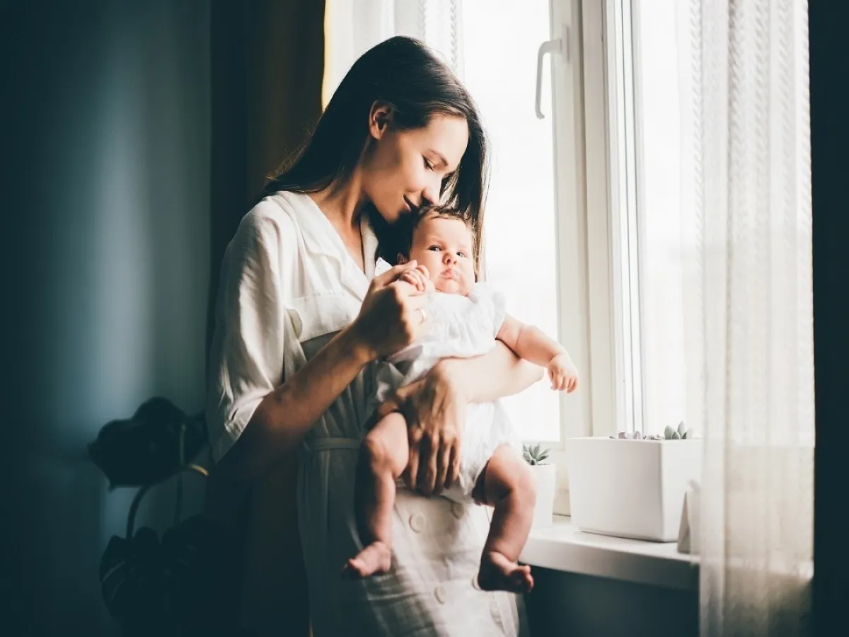 صورة لأم تحمل طفلتها الرضيعة