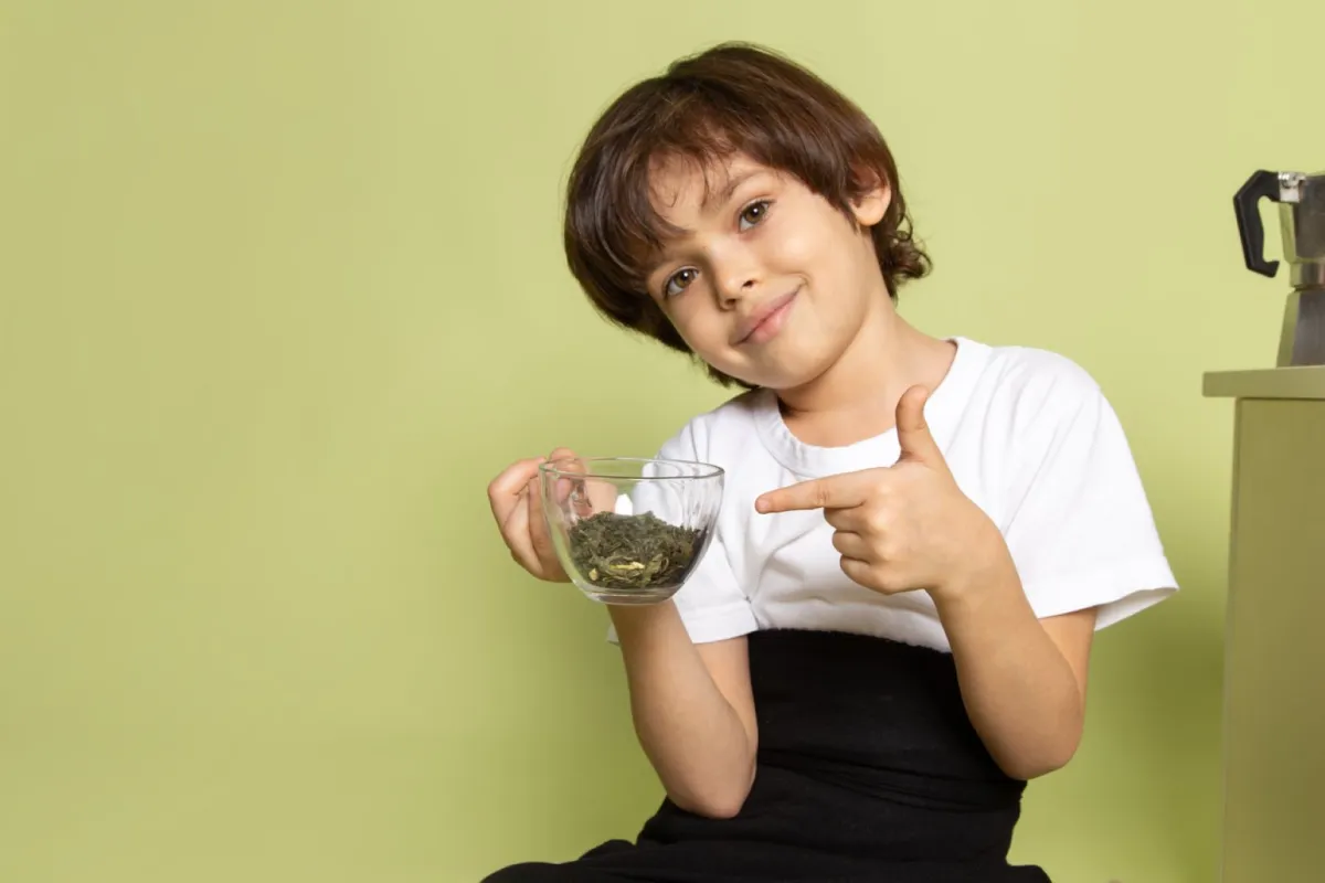 صورة طفل يشير إلى أوراق المورينجا المطحونة