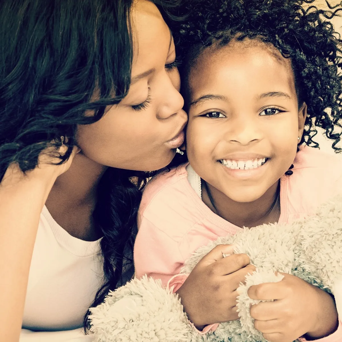 صورة لأم تقبل طفلتها