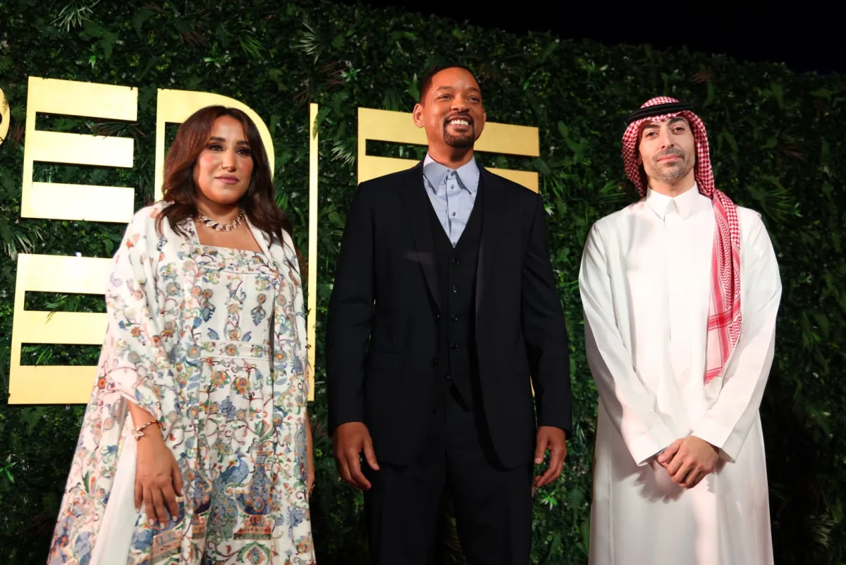 ويل سميث مع الأستاذة جمانا الراشد والأستاذ محمد التركي (Will Smith with Jomana Alrashid and Mohammed Al Turki). مصدر الصورة: Tim P. Whitby/Getty Images for The Red Sea International Film Festival