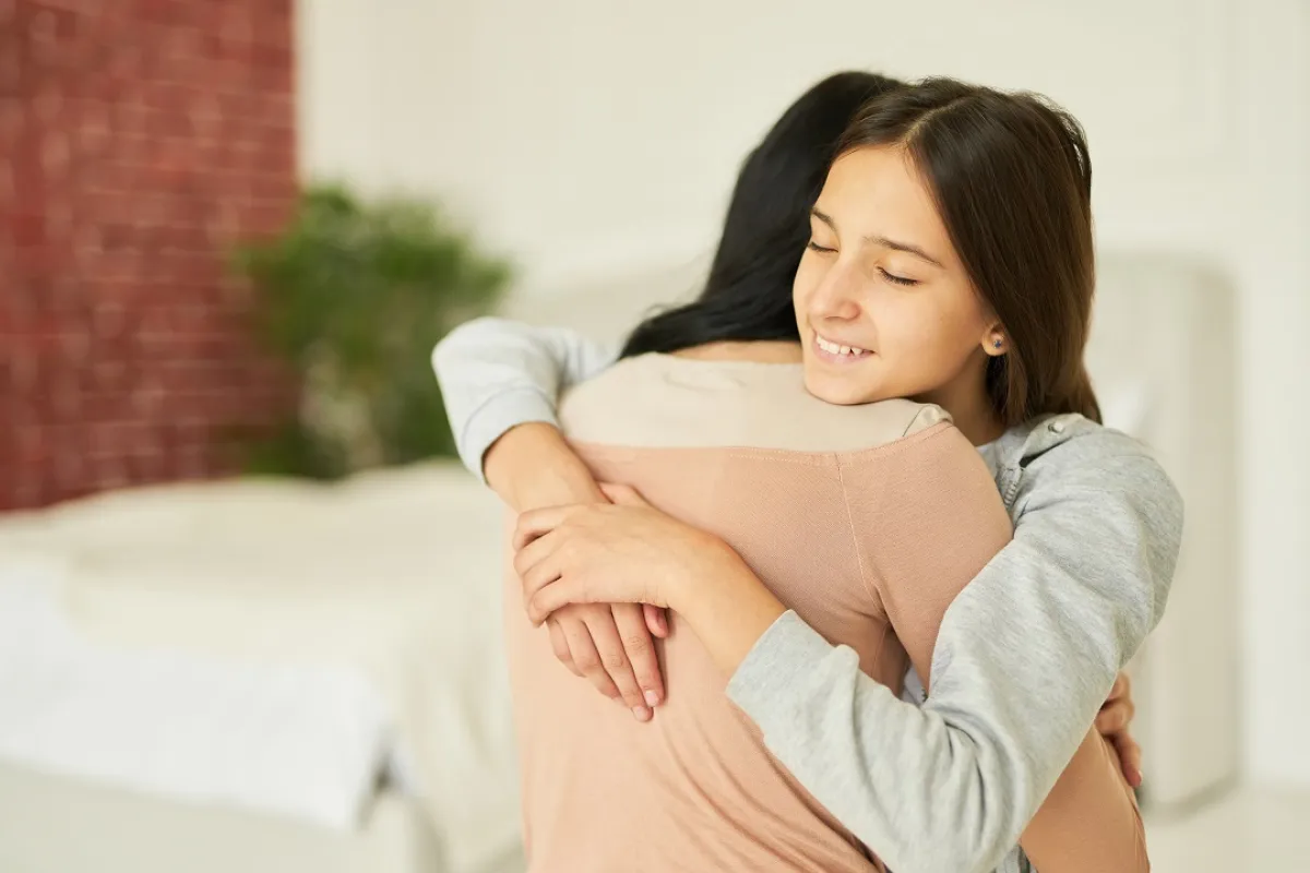 صورة لطفلة تعانق أمها