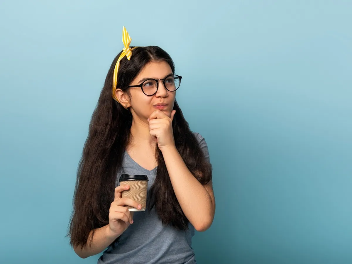 صورة لمراهقة تحمل كوباً من القهوة