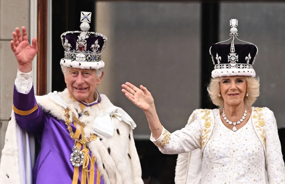 الملك تشارلز والملكة كاميلا يلوحان من شرفة قصر باكنغهام (King Charles III and Queen Camilla wave from the Buckingham Palace). مصدر الصورة: Oli SCARFF / AFP