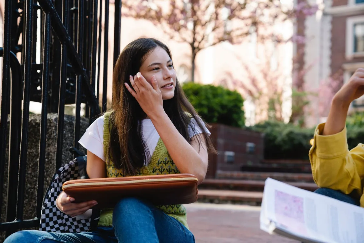 طالبة تجلس على سلالم الجامعة