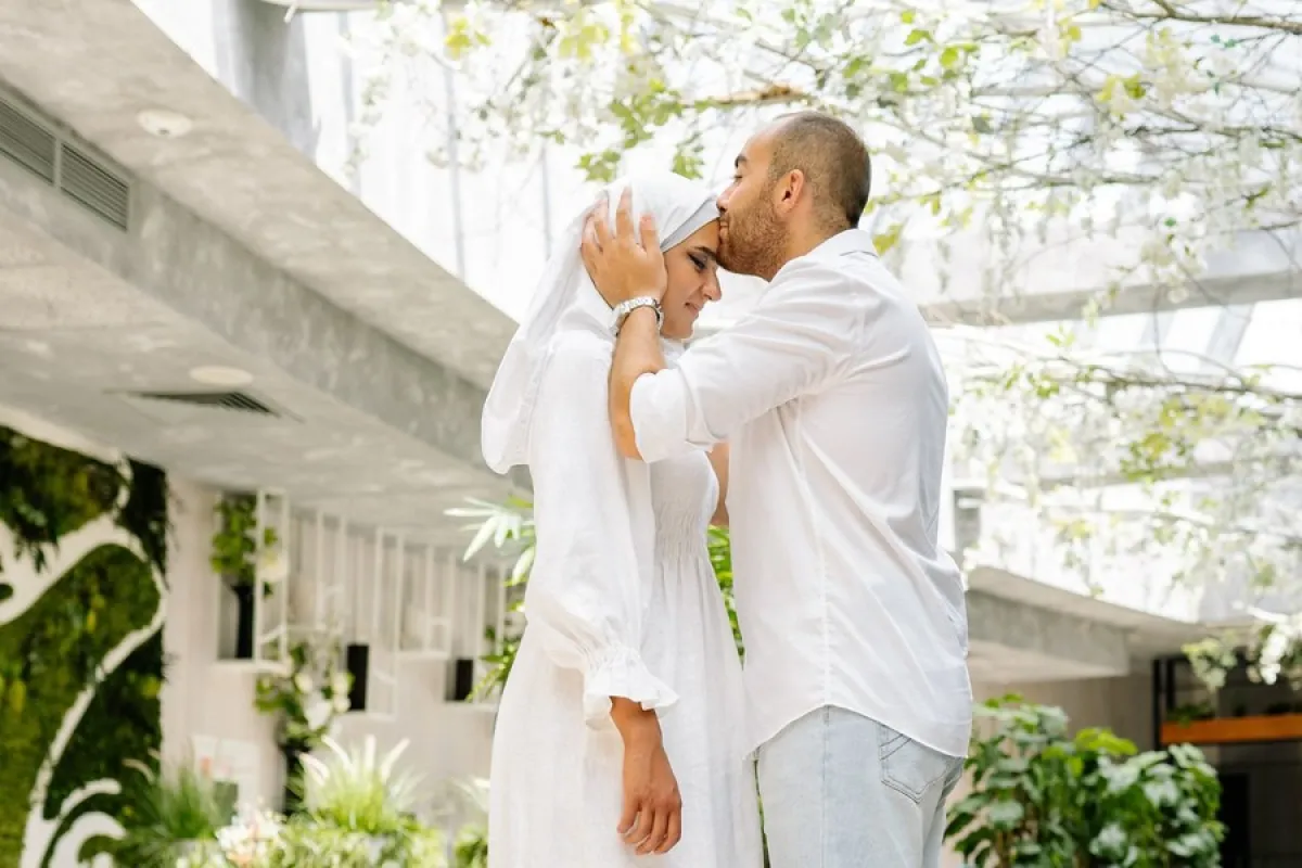 شخص يراضي زوجته المحجبة ويقبلها