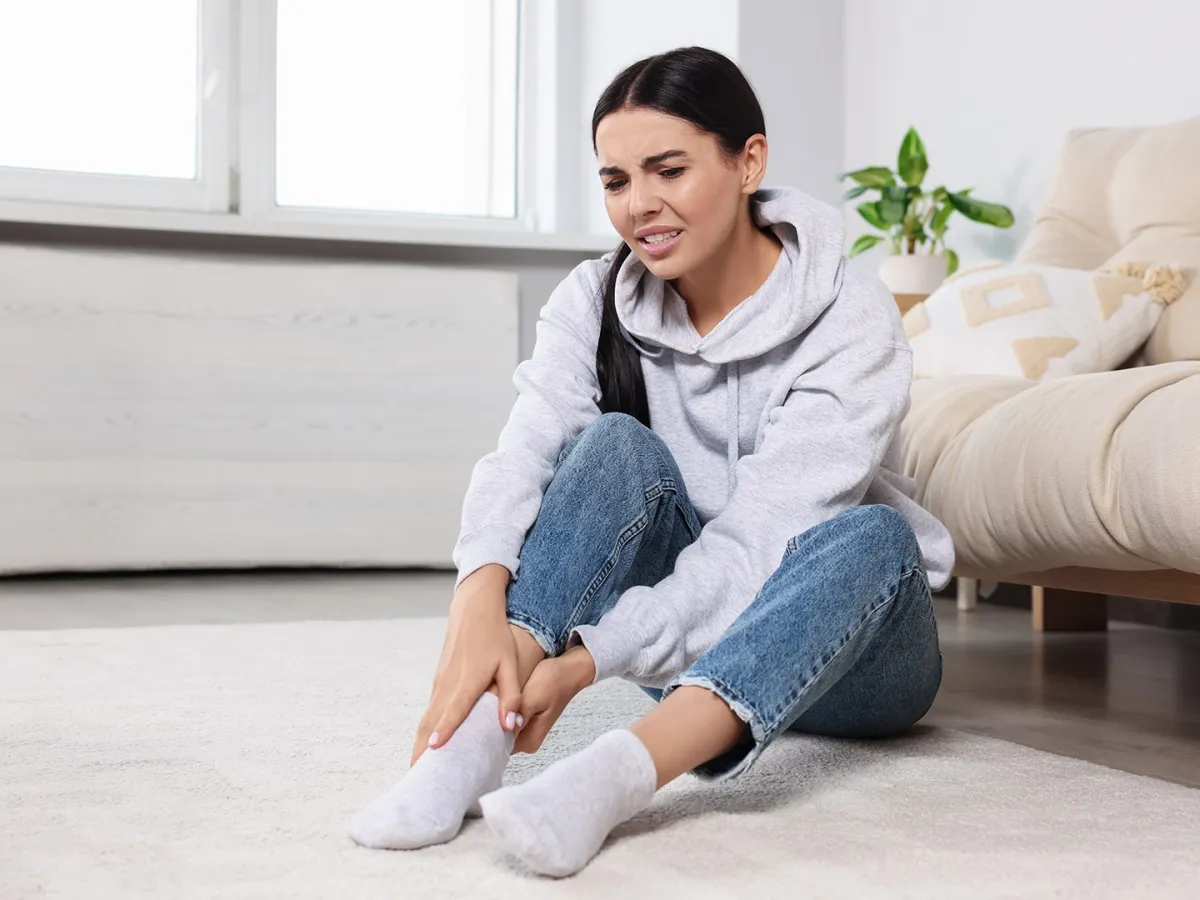 شابة تشعر بألم في كعب القدم