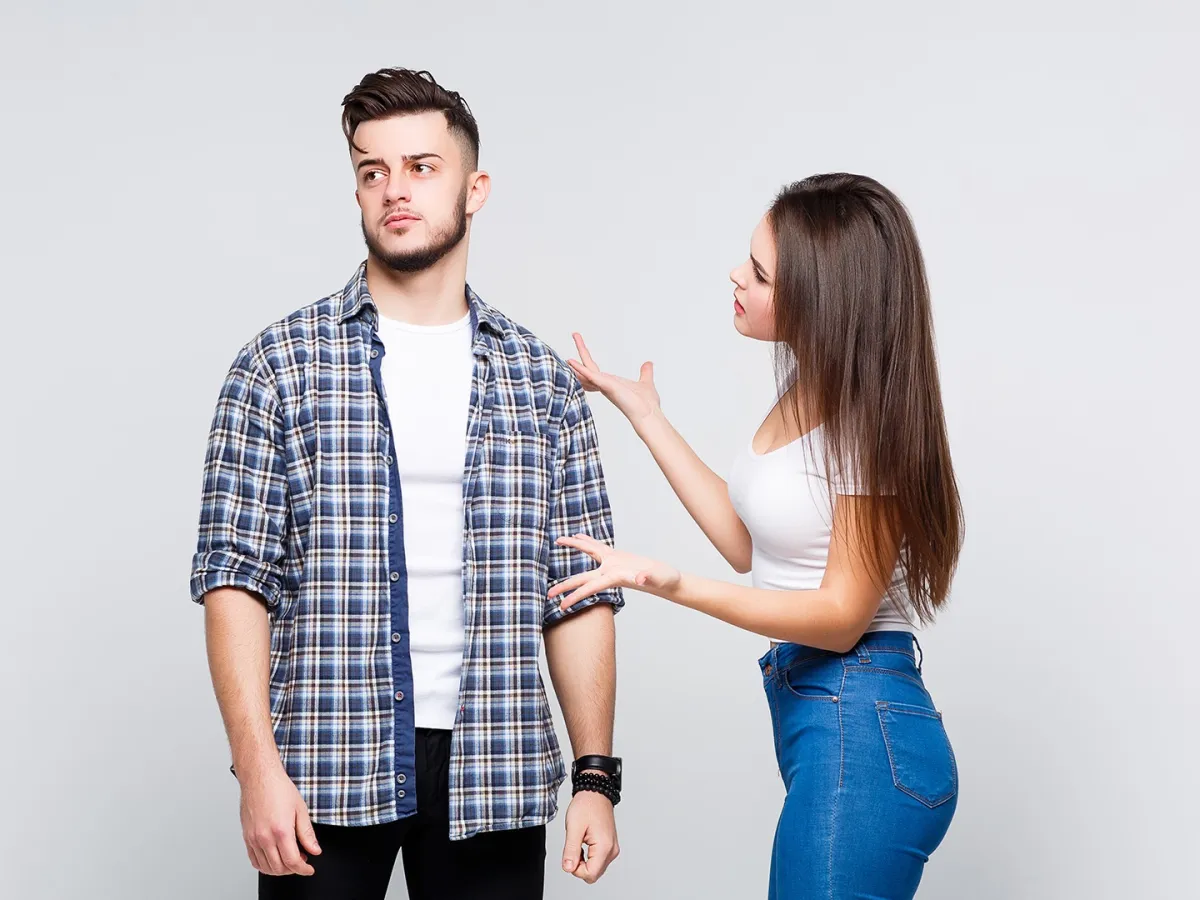 زوجان متخاصمان يبدو عليهما الشقاق وهما جالسان على السرير بحجرة نومهما