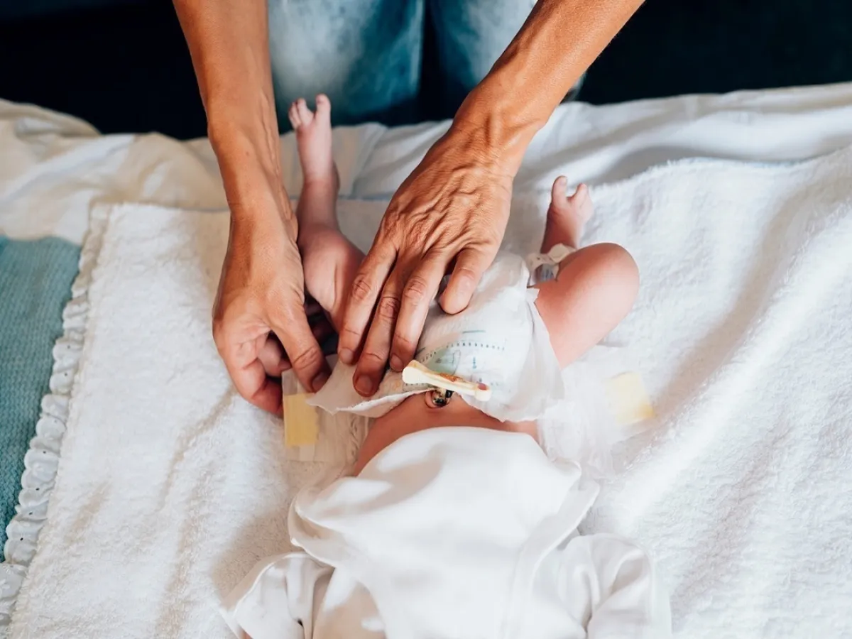 صورة لأم تغير حفاض طفلها 