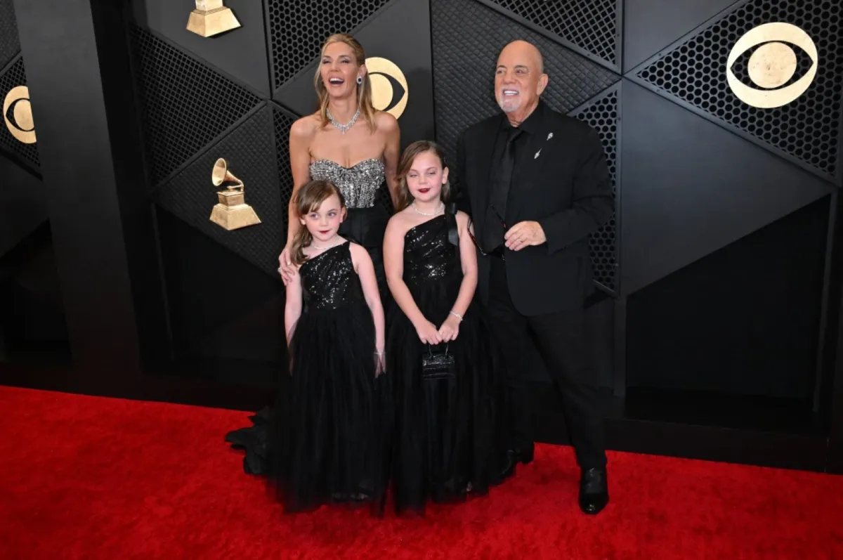بيلي جويل مع زوجته وابنتيه ريمي آن وديلا روز في حفل توزيع جوائز غرامي (Billy Joel with his wife and daughters Remy Anne and Della Rose at  the 66th Annual Grammy Awards). مصدر الصورة: Robyn BECK / AFP