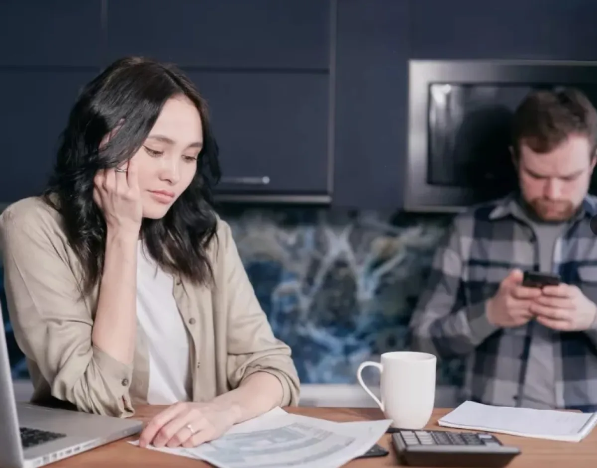 زوجة صامتة تجلس أمام جهازها اللوحي وزوج يبدو متشاغلاً بهاتفه المحمول