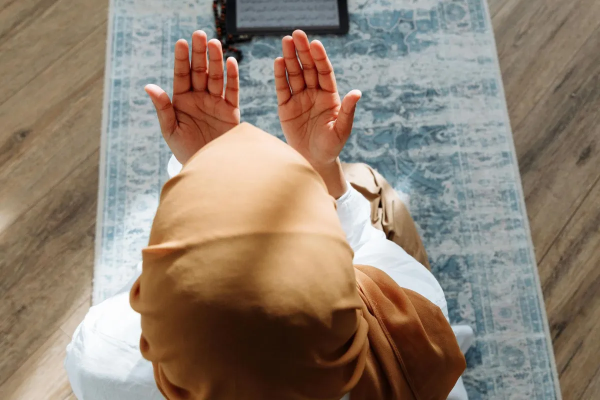 فتاة ترفع يدها بالدعاء لله سبحانه وتعالى