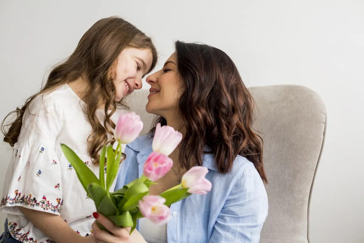 صورة لطفلة تقدم الورود لأمها