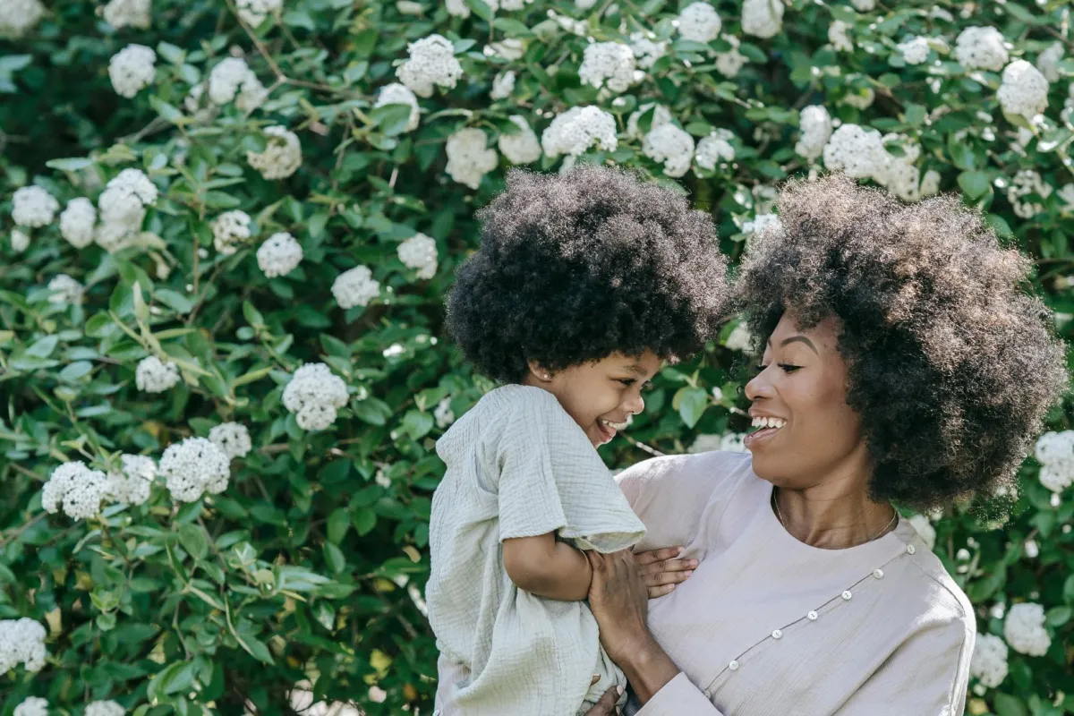 أم تحتضن ابنتها وهما تتضاحكان بسعادة بين أحضان الطبيعة