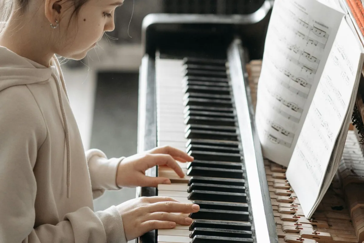 عازفة تعزف على البيانو من خلال النوتة الموسيقية