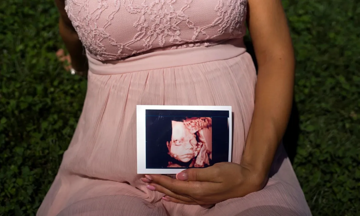 صورة حامل تحمل صورة الجنين