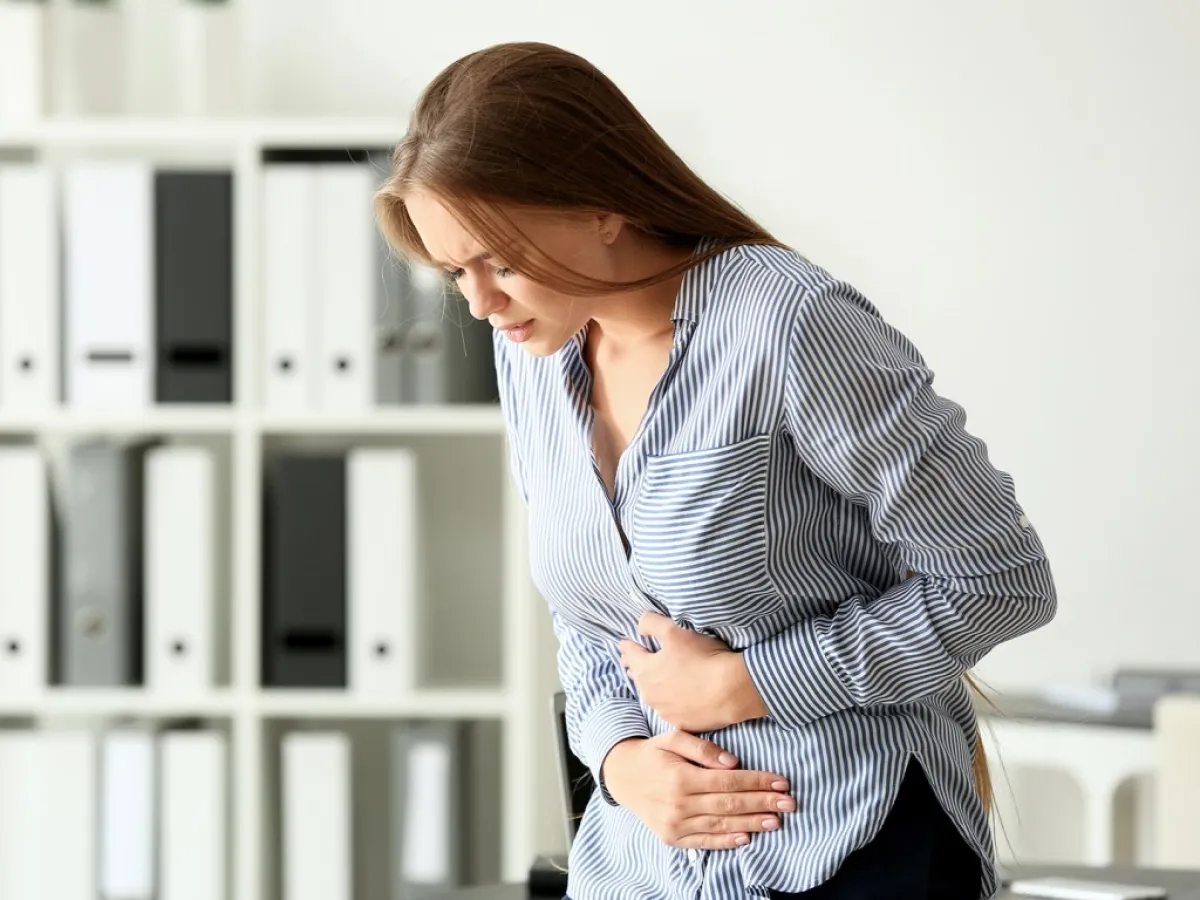 امرأة تعاني من ألم شديد في البطن بسبب التسمم الغذائي