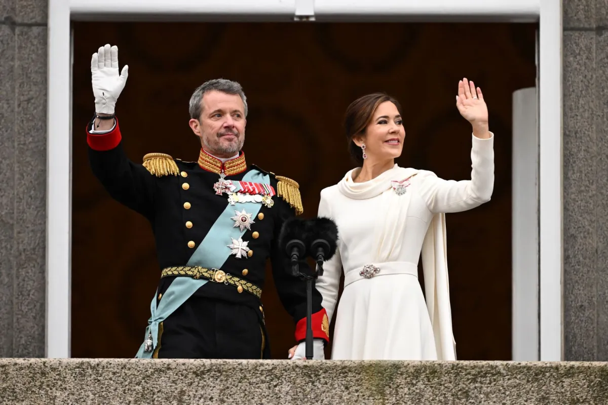 الملكة ماري ترتدي فستانا أبيض اللون وتقف بجوار زوجها على شرفة القصر لتحية الجماهير