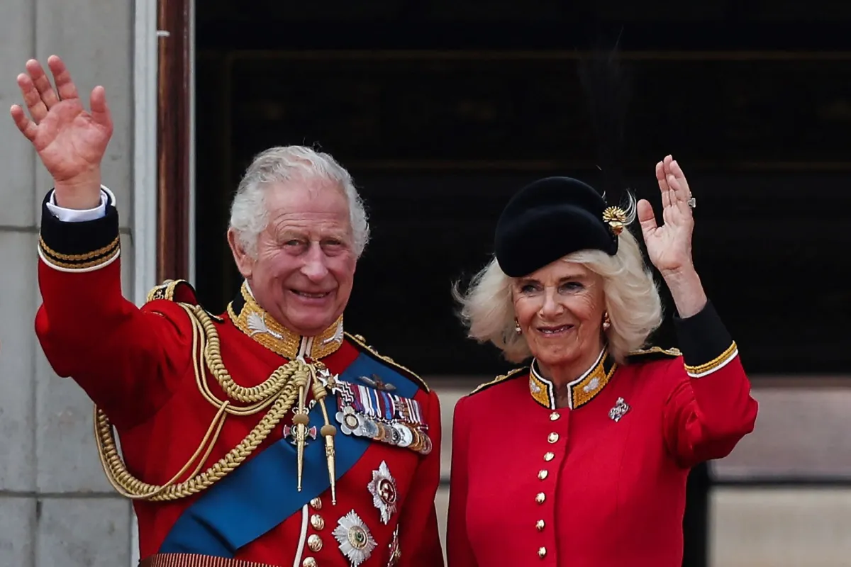 الملك تشارلز الثالث والملكة كاميلا يلوحان من شرفة قصر باكنغهام في لندن (King Charles III and Queen Camilla wave from the balcony of Buckingham Palace in London). مصدر الصورة: Adrian DENNIS / AFP
