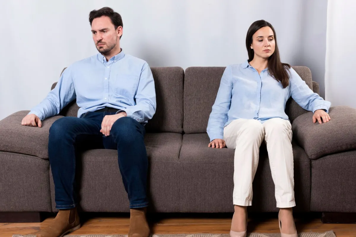 زوجان يبدوان متخاصمان كل يجلس على طرف من الأريكة 
