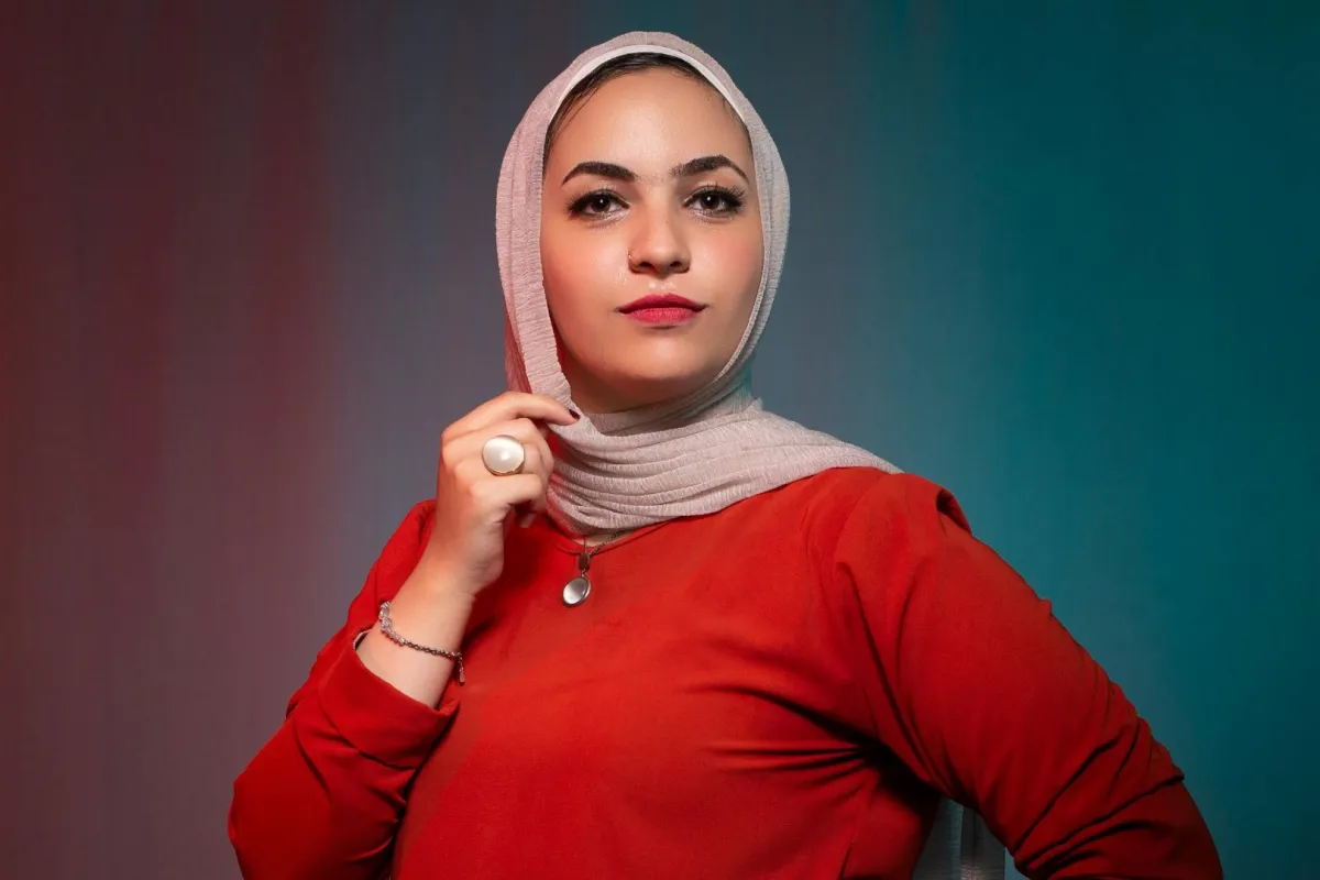 فتاة قوية تقف بثبات ترتدي فساتانا احمر اللون