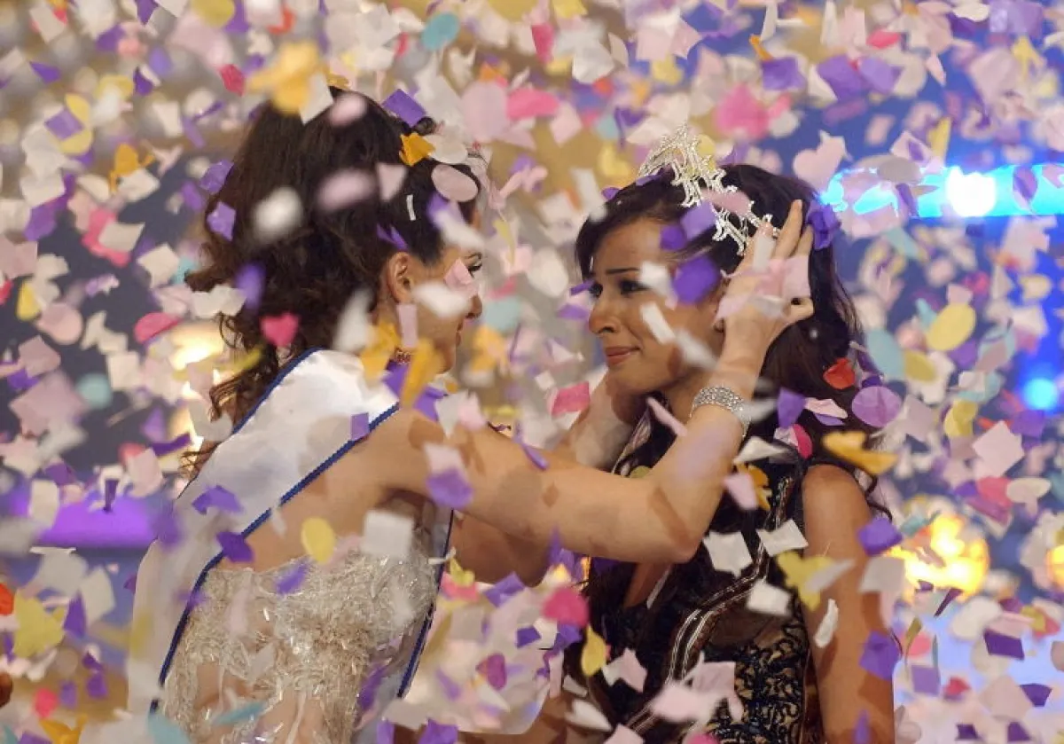 Miss Lebanon 2003 Marie-Jose Hnein (L) fixes the crown on the head of Nadine Njiem late 18 June 2004 after she was elected Miss Lebanon 2004 in Beirut. AFP PHOTO/Haitham Mussawi (Photo by HAITHAM MUSSAWI / AFP)