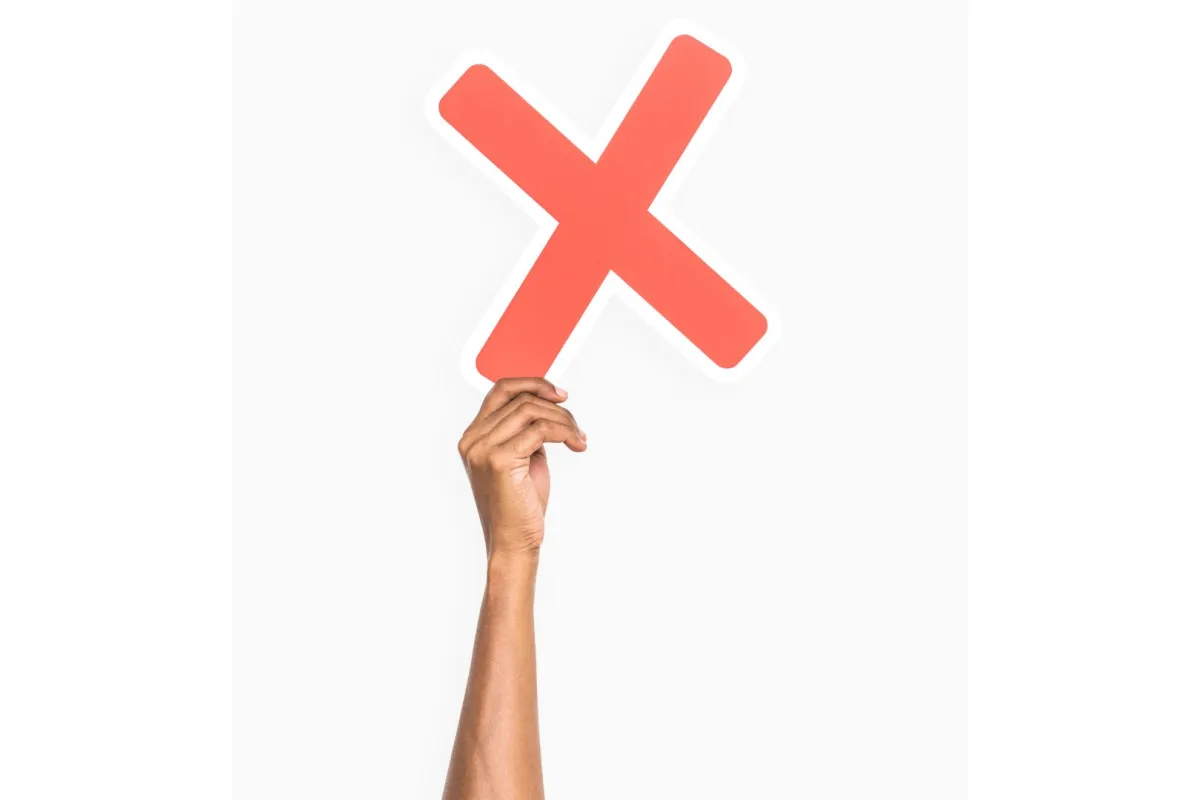 شاب يُمسك علامة خطأ بيده