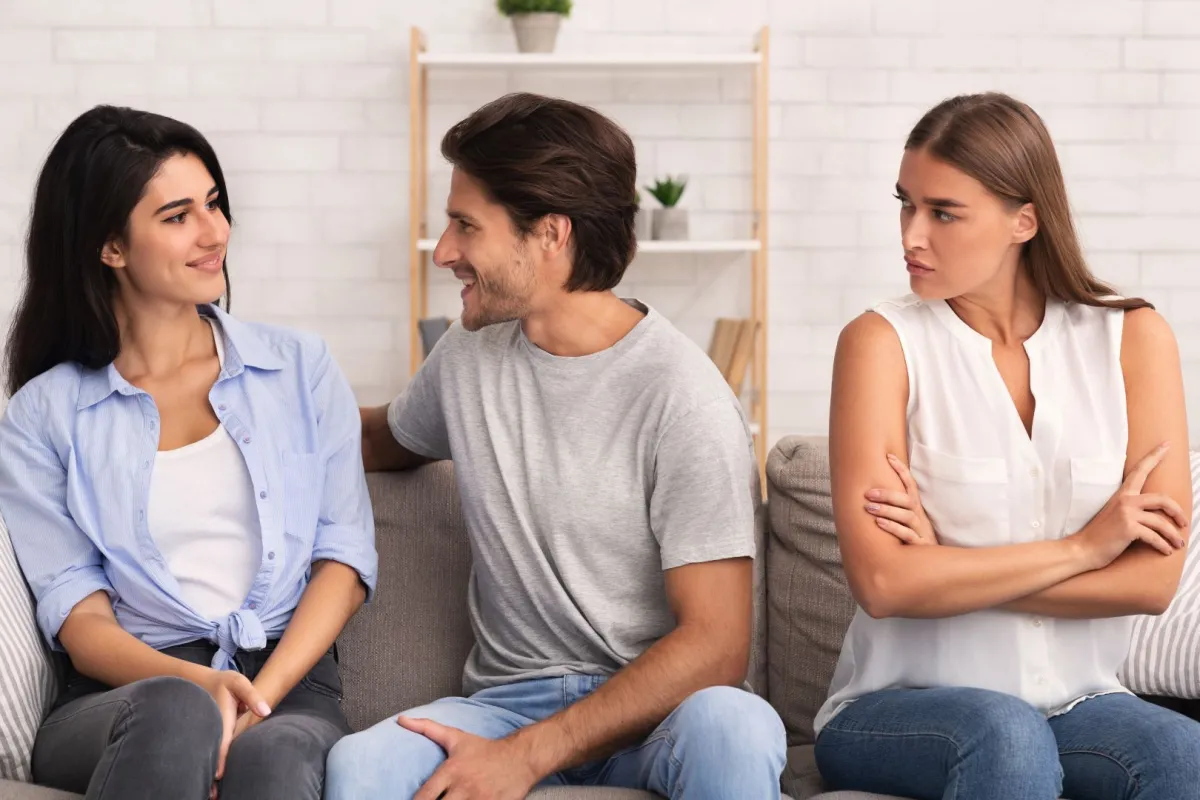 فتاة تنظر إلى صديقها وهو يتحدث مع صديقتها